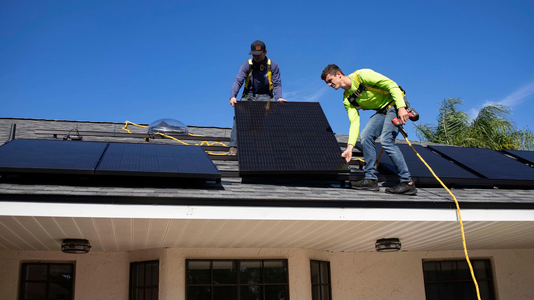 Técnicos montando un panel solar sobre una vivienda